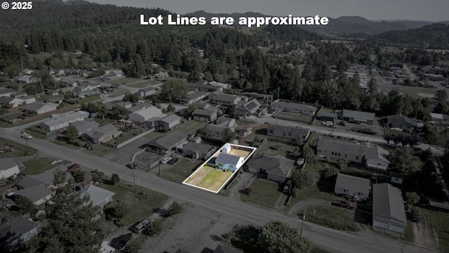 1636 Maple St, Myrtle Point, OR 97458 - aerial view of property and surrounding area featuring a heavily wooded area, property parcel outlined, and a mountain backdrop