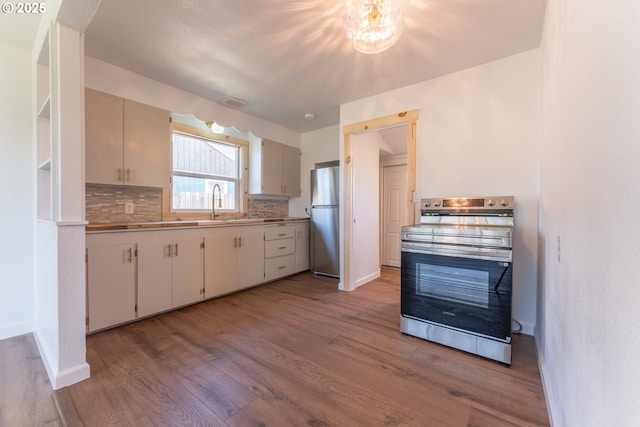 1636 Maple St, Myrtle Point, OR 97458 - kitchen featuring stainless steel appliances, wood finished floors, tasteful backsplash, and baseboards