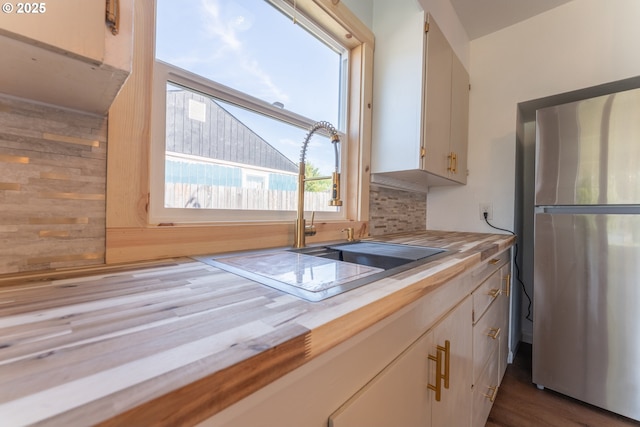 1636 Maple St, Myrtle Point, OR 97458 - kitchen featuring freestanding refrigerator, a sink, backsplash, and wood finished floors