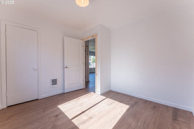 1636 Maple St, Myrtle Point, OR 97458 - unfurnished bedroom with wood finished floors, baseboards, and heating unit