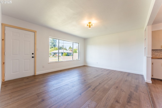 1636 Maple St, Myrtle Point, OR 97458 - unfurnished living room with dark wood-type flooring and baseboards