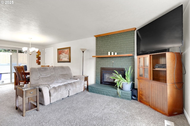 living area featuring visible vents, a textured ceiling, an inviting chandelier, a fireplace, and carpet flooring