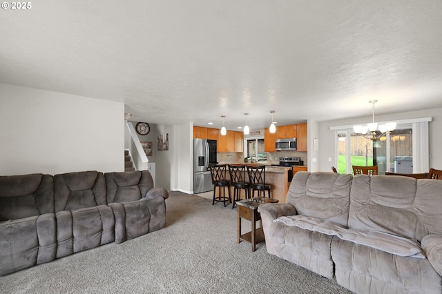 living area with a notable chandelier, stairway, and light colored carpet