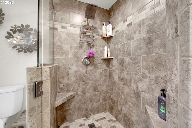 full bath with toilet and a tile shower