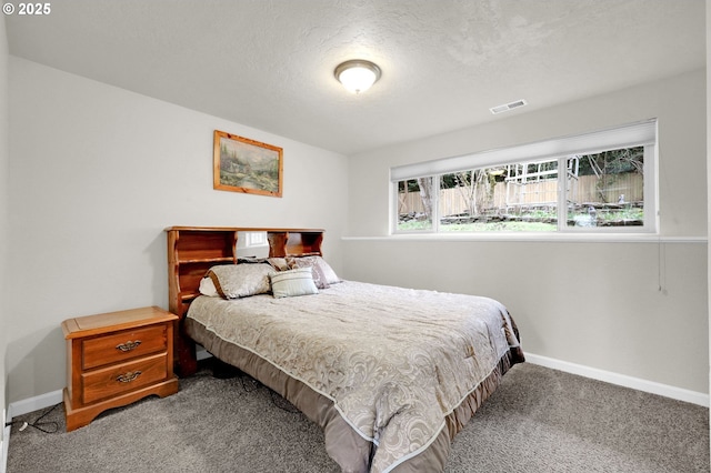 carpeted bedroom featuring baseboards, visible vents, and a textured ceiling