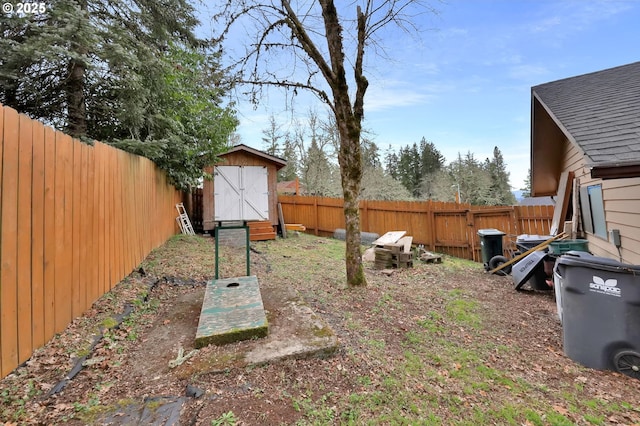 view of yard featuring a fenced backyard, a storage shed, and an outdoor structure