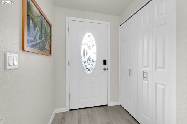 entrance foyer with baseboards and light wood-style flooring