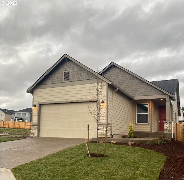 craftsman inspired home featuring a garage and a front lawn