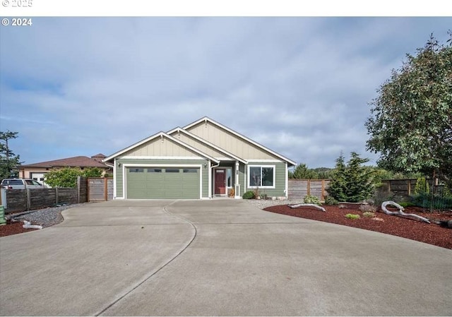 view of front of property featuring driveway, an attached garage, fence, and board and batten siding