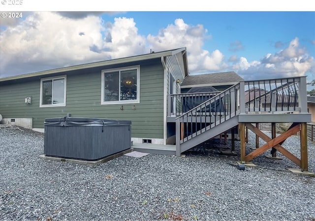 back of property with crawl space, a hot tub, stairway, and a wooden deck