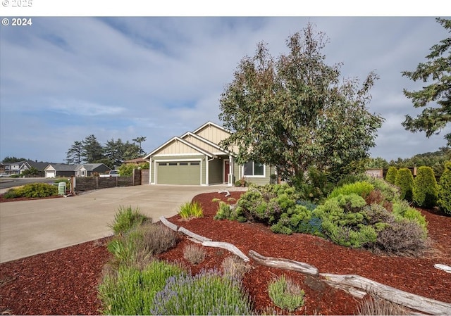 craftsman-style home with board and batten siding, driveway, a garage, and fence