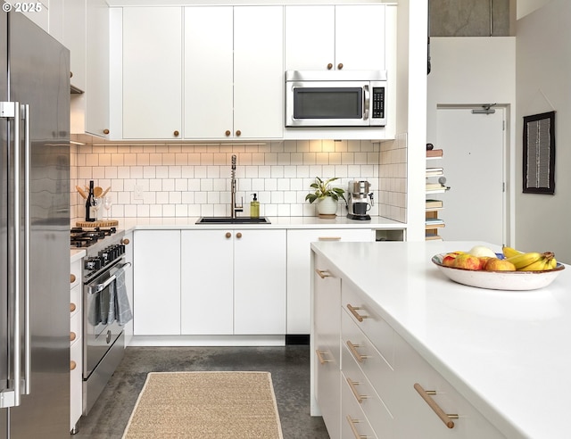 1507 SE 45th Ave Unit 308, Portland, OR 97215 - kitchen featuring appliances with stainless steel finishes, a sink, light countertops, white cabinets, and decorative backsplash
