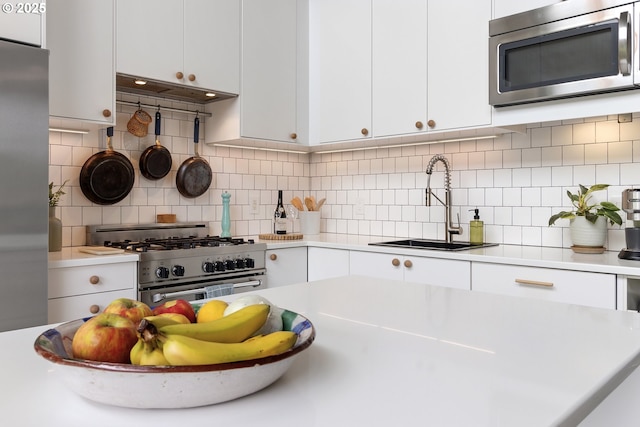 1507 SE 45th Ave Unit 308, Portland, OR 97215 - kitchen featuring appliances with stainless steel finishes, a sink, light countertops, and white cabinetry