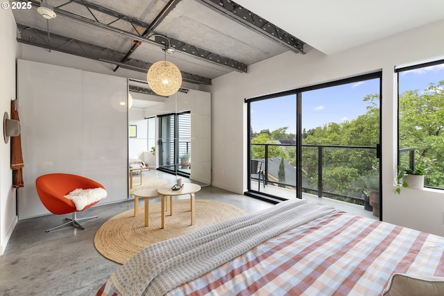 1507 SE 45th Ave Unit 308, Portland, OR 97215 - bedroom featuring concrete floors, multiple windows, access to exterior, beam ceiling, and baseboards