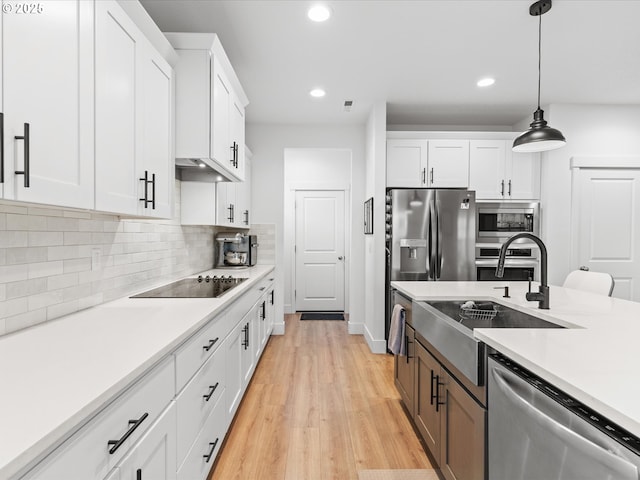 kitchen featuring tasteful backsplash, appliances with stainless steel finishes, white cabinets, and light countertops