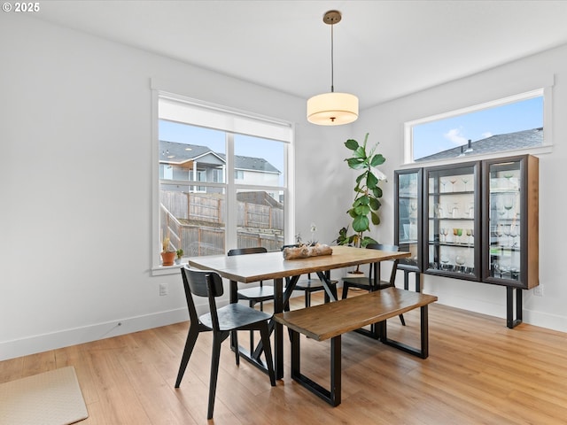 dining space with light wood-style floors and baseboards