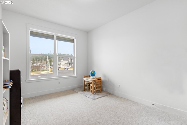 carpeted spare room featuring baseboards