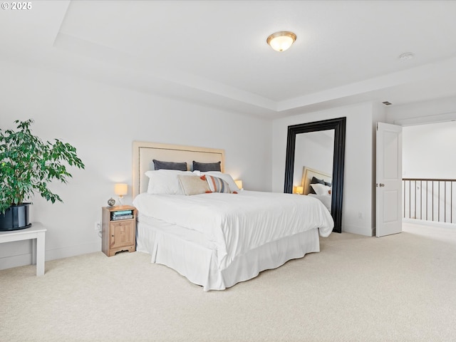 carpeted bedroom with a tray ceiling