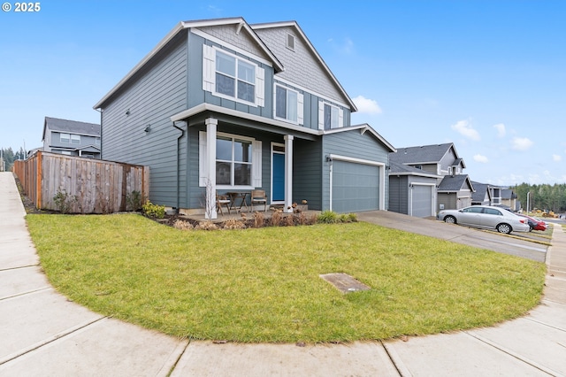 view of front of home with a garage, covered porch, and a front lawn