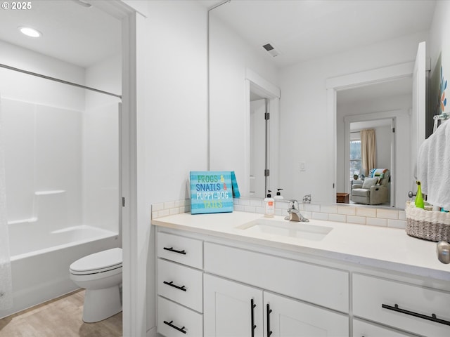 bathroom featuring visible vents, toilet, wood finished floors, vanity, and shower / bathing tub combination