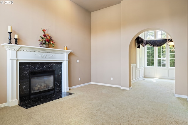 2103 N Teakwood St, Canby, OR 97013 - unfurnished living room with carpet floors, a high ceiling, a high end fireplace, and arched walkways