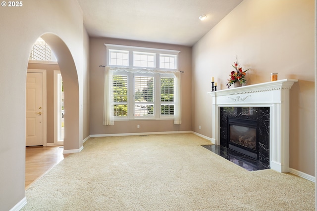 2103 N Teakwood St, Canby, OR 97013 - unfurnished living room with carpet, a premium fireplace, arched walkways, and lofted ceiling