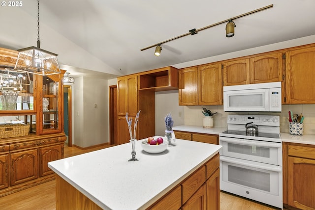 14216 NE 346th St, Battle Ground, WA 98604 - kitchen with white appliances, light countertops, vaulted ceiling, brown cabinetry, and light wood finished floors