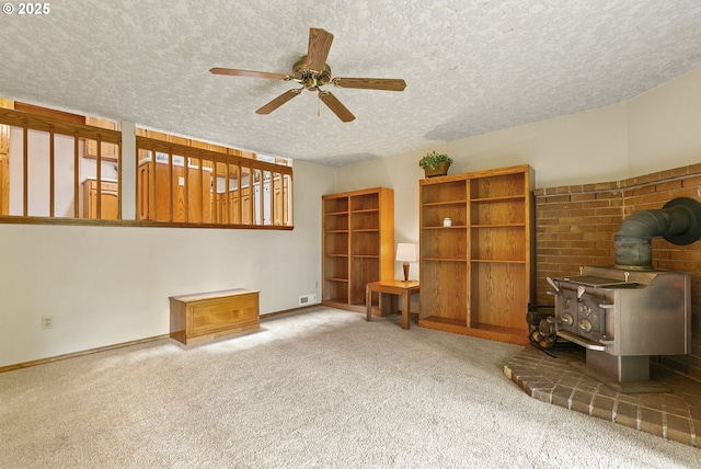 14216 NE 346th St, Battle Ground, WA 98604 - living area featuring a wood stove, carpet, a textured ceiling, ceiling fan, and baseboards