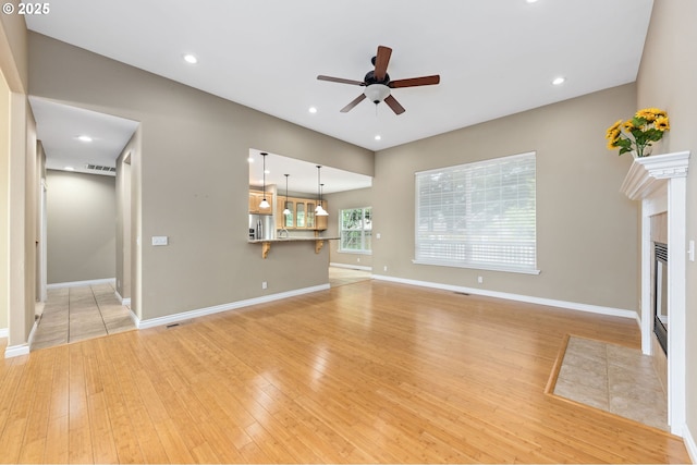 115 Duane Ct, Myrtle Creek, OR 97457 - unfurnished living room featuring ceiling fan, light wood-style flooring, baseboards, recessed lighting, and a tile fireplace