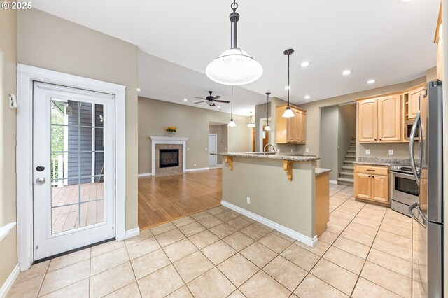 115 Duane Ct, Myrtle Creek, OR 97457 - kitchen with appliances with stainless steel finishes, a peninsula, a breakfast bar, open floor plan, and light brown cabinets