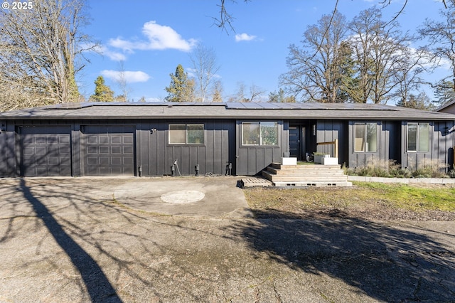 back of house featuring a garage and solar panels