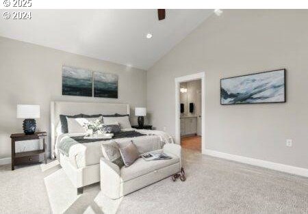 carpeted bedroom with ceiling fan, high vaulted ceiling, and ensuite bath