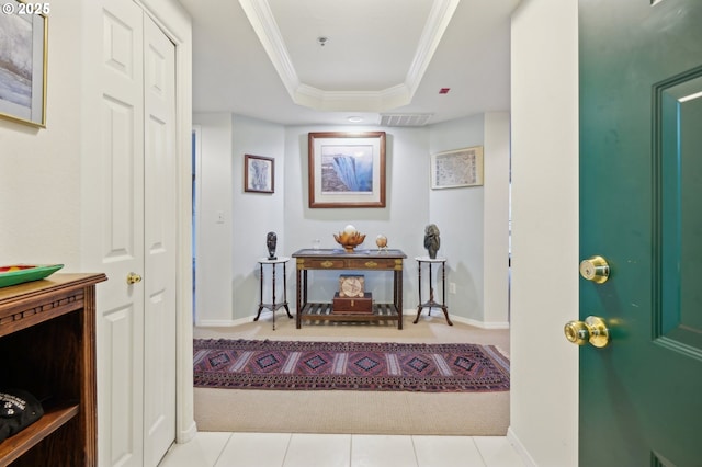 tiled entrance foyer with ornamental molding, a tray ceiling, visible vents, and baseboards