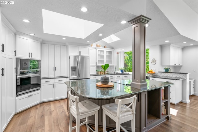 1433 SE 49th Ct, Hillsboro, OR 97123 - kitchen with recessed lighting, a skylight, white cabinetry, and stainless steel fridge with ice dispenser