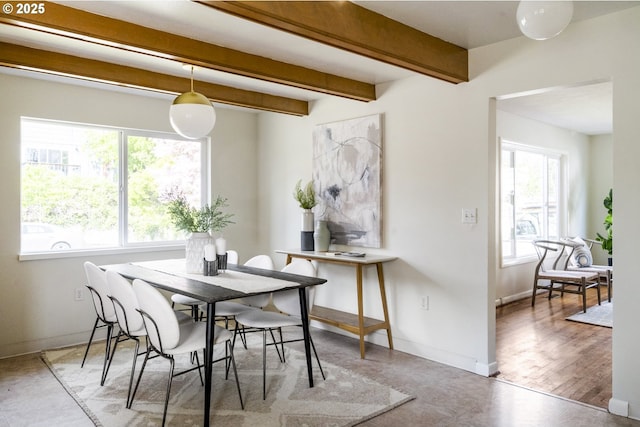 dining space with beamed ceiling and baseboards