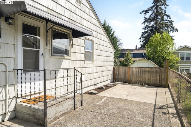 view of patio / terrace featuring fence, an outbuilding, and a storage shed