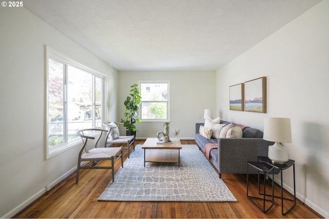 living room with healthy amount of natural light, wood finished floors, and baseboards