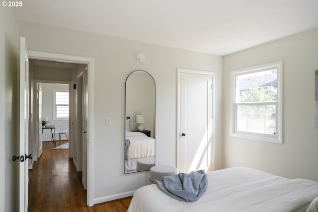 bedroom with baseboards and dark wood-type flooring