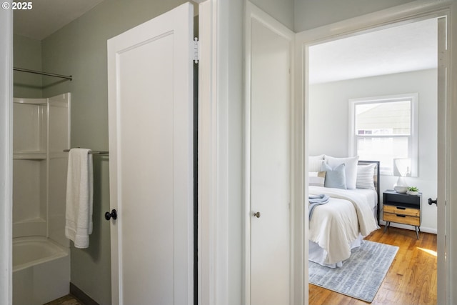 full bath with wood finished floors,  shower combination, and connected bathroom