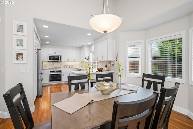 dining room with wood finished floors, baseboards, and recessed lighting