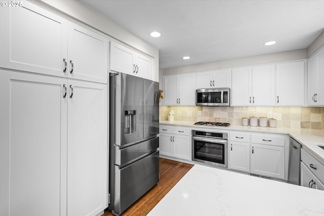 kitchen with stainless steel appliances, dark wood finished floors, white cabinetry, and recessed lighting