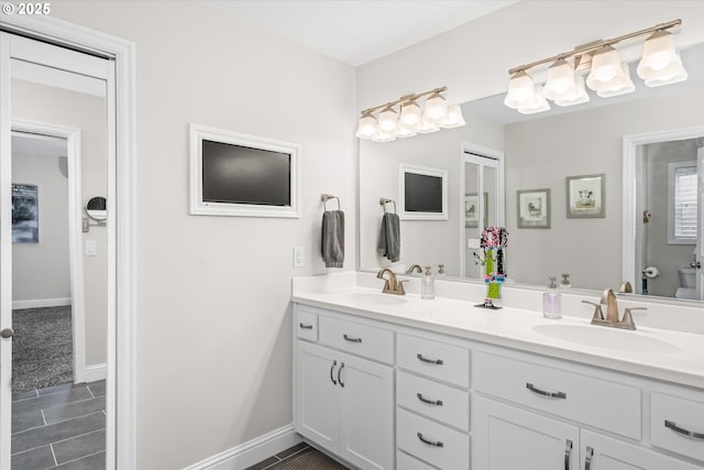 full bath featuring double vanity, toilet, baseboards, and tile patterned floors