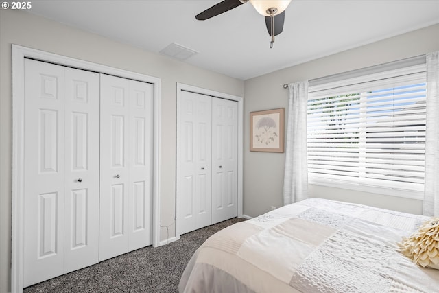 bedroom featuring carpet, multiple closets, ceiling fan, and baseboards