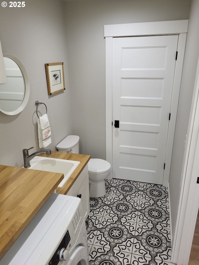 23538 NW Saint Helens Rd Unit S5, Portland, OR 97231 - half bathroom featuring washer / dryer, toilet, vanity, and tile patterned flooring