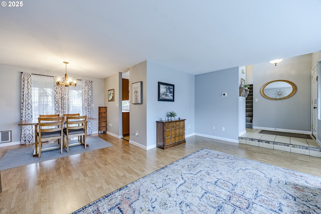 dining area featuring baseboards, stairway, an inviting chandelier, and wood finished floors