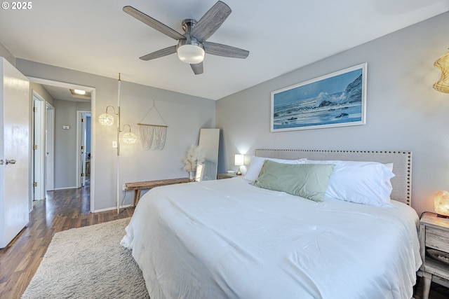 bedroom with ceiling fan, baseboards, and dark wood-style flooring