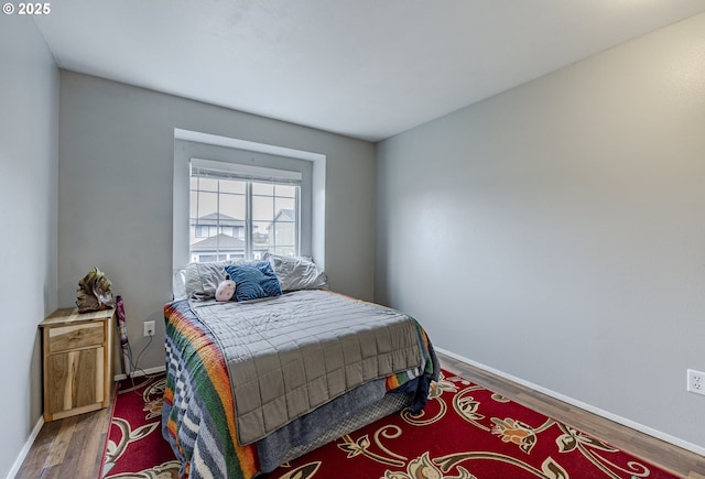 bedroom with baseboards and wood finished floors