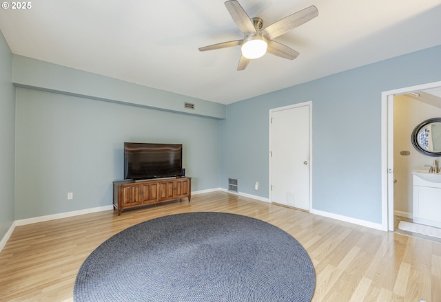 living area featuring a ceiling fan, wood finished floors, visible vents, and baseboards