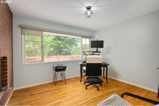 office with wood finished floors, a textured ceiling, and baseboards
