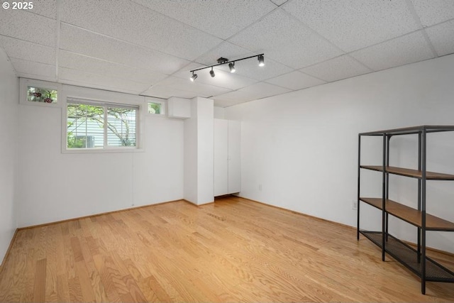 unfurnished bedroom featuring light wood-style flooring, a drop ceiling, and rail lighting